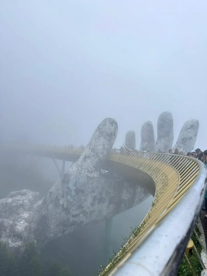 The Golden Bridge and its giant stone hands surrounded by mist in Da Nang
